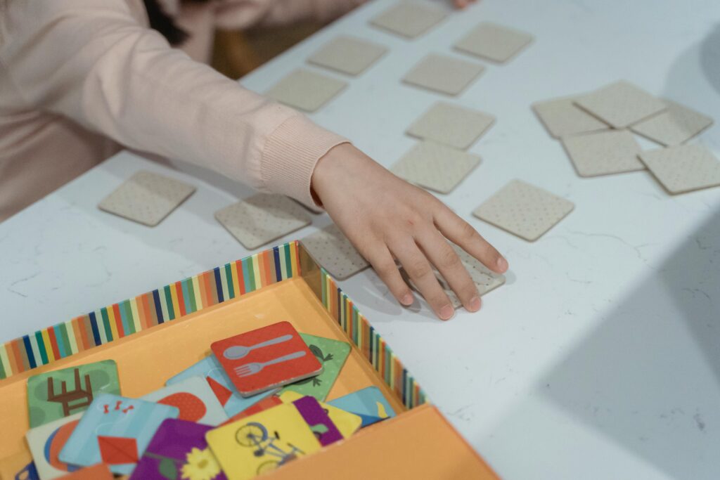 pexels-photo-7943257-7943257 A child engages in a fun memory matching card game, showcasing focus and concentration.
